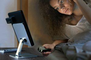 woman in bed controlling an UNIBITRI Remote Page Turner