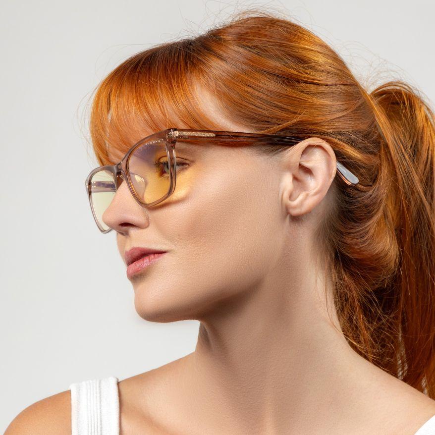 Woman wearing Gunnar Optiks Tindra Rose Latte glasses with amber lenses.